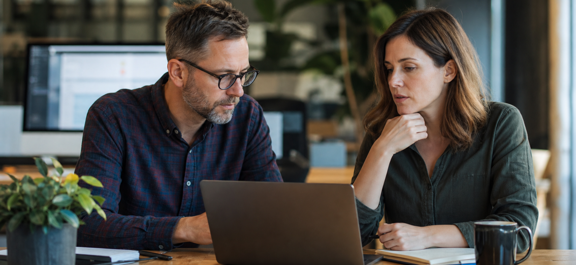 Small business owner and sales manager reviewing lead follow-up priorities together in a modest office