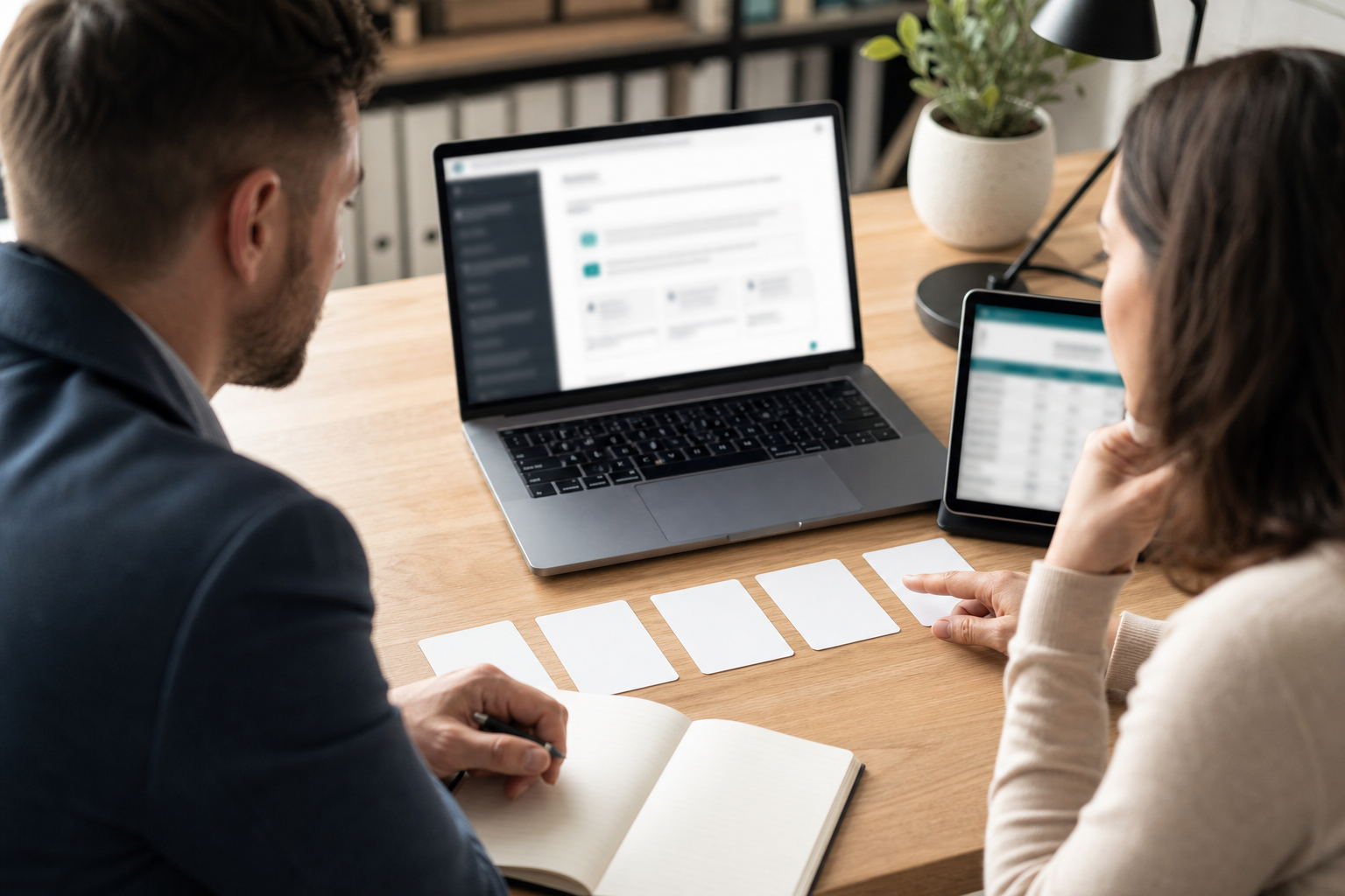 Business owner and consultant reviewing AI search visibility test results with blurred screens
