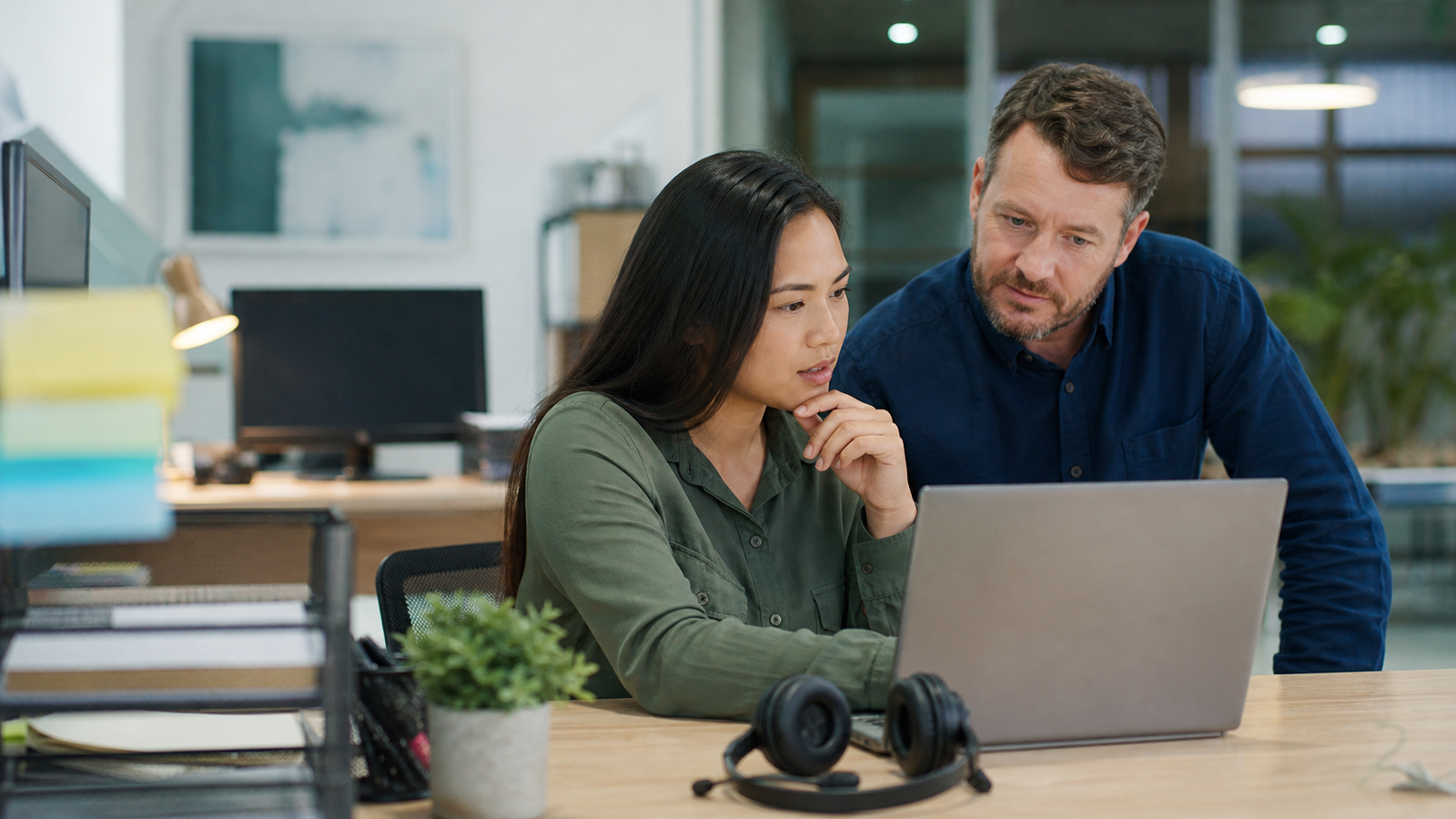 Support agent and operations lead reviewing an unreadable internal reference screen before escalating a customer issue